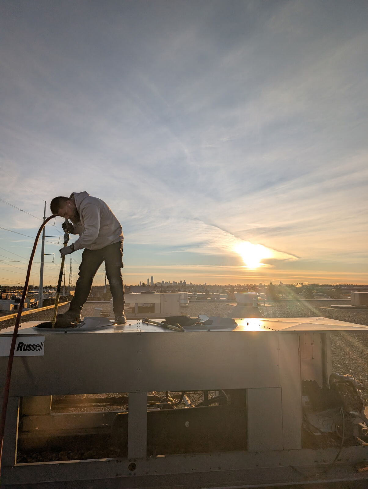 Technician rooftop sunset skyline